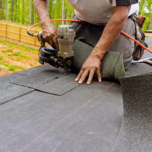 Person placing shingles on a roof