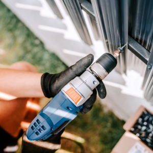 Person drilling into a fence